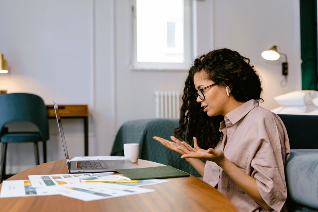 Professionnelle destabilisée  face à son ordinateur, en période de transition professionnelle et de questionnement sur sa manière de travailler.
